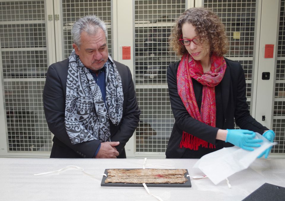 Stéphanie Leclerc-Caffarel, head of Oceanic Collections at the Musée du Quai Branly–Jacques Chirac, presents the fragment of maro 'ura to Heremoana Maamaatuiahutapu, the culture minister of French Polynesia © Gaëtan Deso
